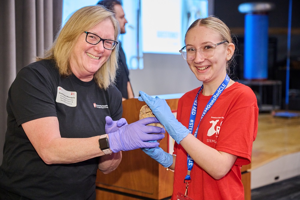 Girl and doctor holding a preserved human heart.
